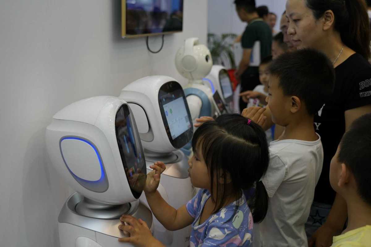 Children are playing with the robots in Smart China Expo