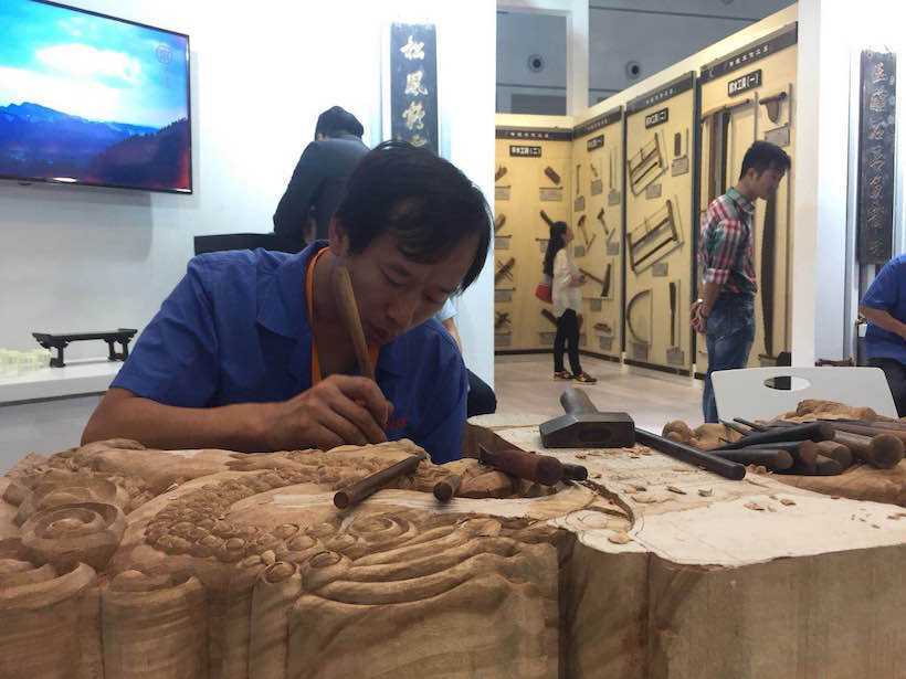 Craftsman is carving on wood in Yubei District Pavilion