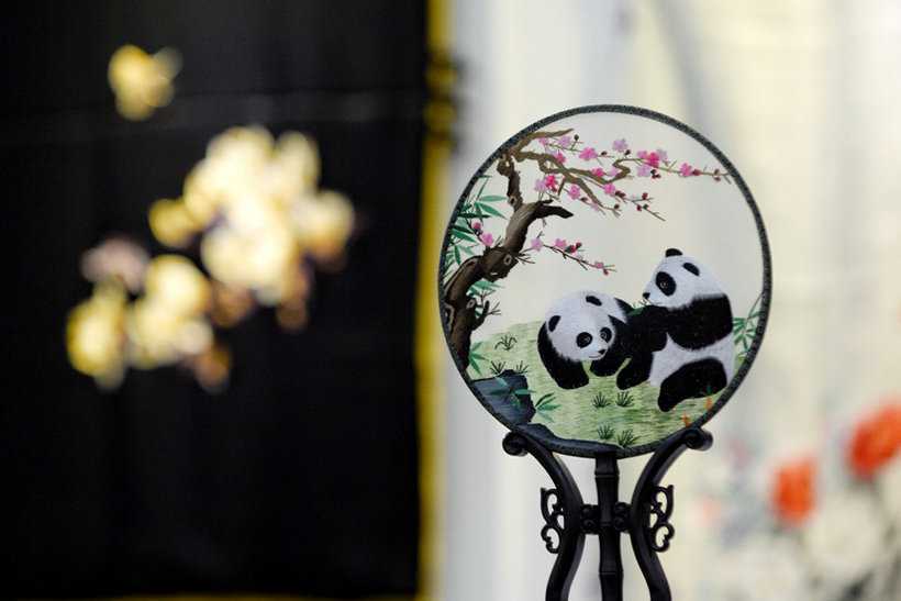 A hand fan with embroidered panda