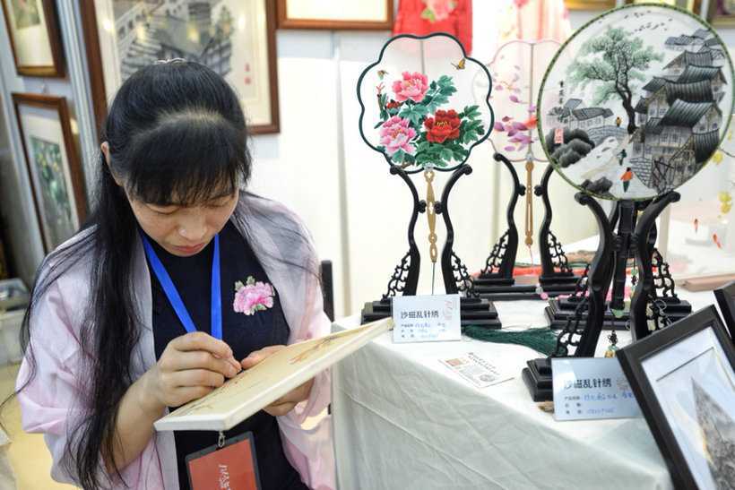 Yan Yongxia is showing the unique embroidery technique at the exhibition.