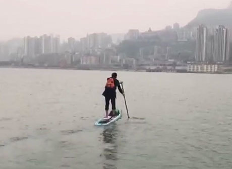 A Young Fellow in Wanzhou Takes Paddle Board to Work