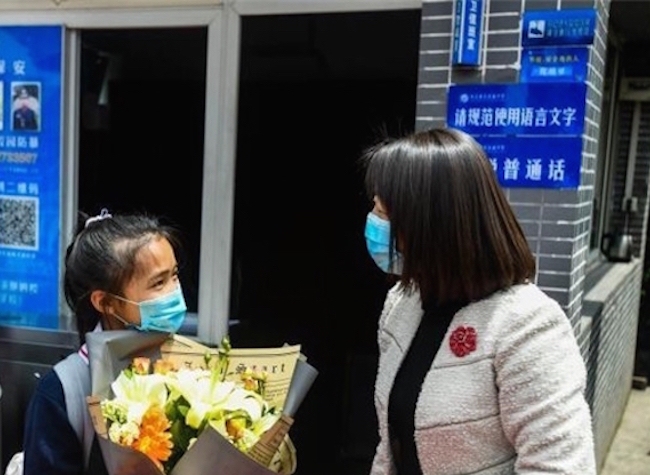 The First Student Back to Qiezixi Middle School Receives Flowers from the Headmistress