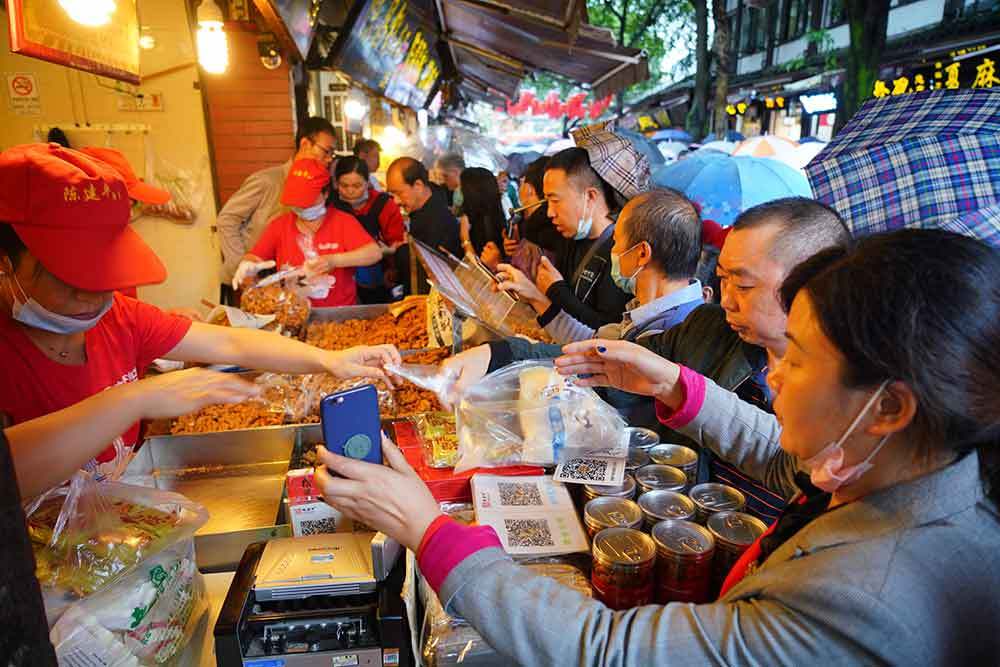 Tourists in Ciqikou ancient town eager to buy Fried Dough Twists. (Photo/ Shangyou News)