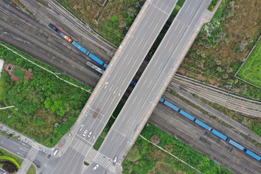 Aerial photo taken on March 19, 2021 shows a Yuxinou (Chongqing-Xinjiang-Europe) China-Europe freight train running beneath a bridge in southwest China's Chongqing Municipality. (Xinhua/Tang Yi)