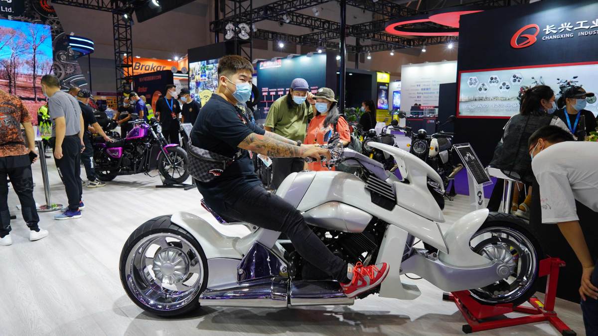 A young customer is trying on the new motorcyle on the expo.(Photo/Wang Xiaoyan)