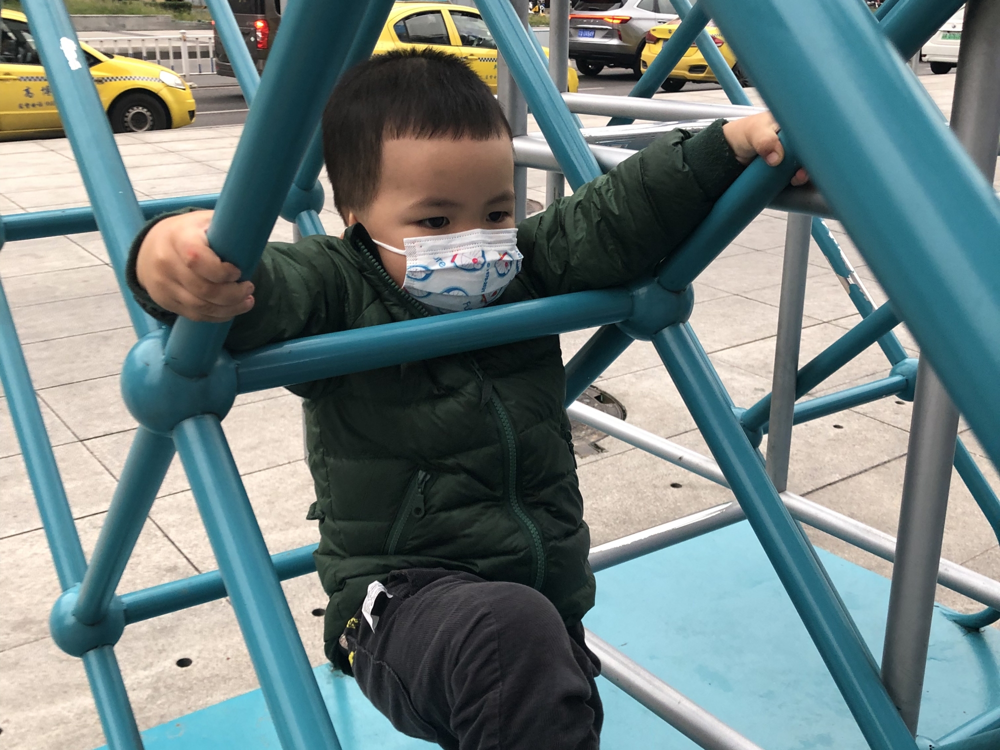 Ethan, wearing a mask in public even as he plays and climbs.