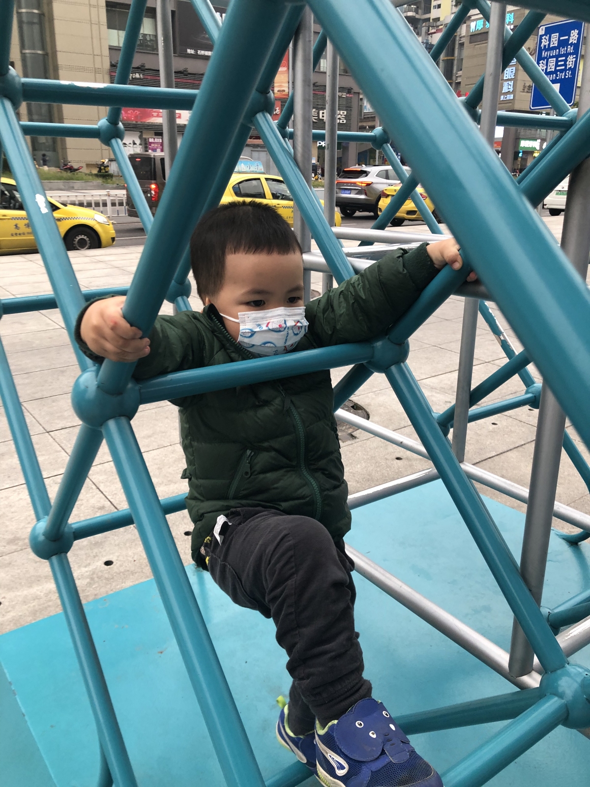 Ethan, wearing a mask in public even as he plays and climbs.