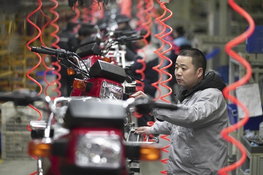 A Worker is assembling motorcycle on a production line of a motorcycle company in Beibei District, Chongqing, on February 9.