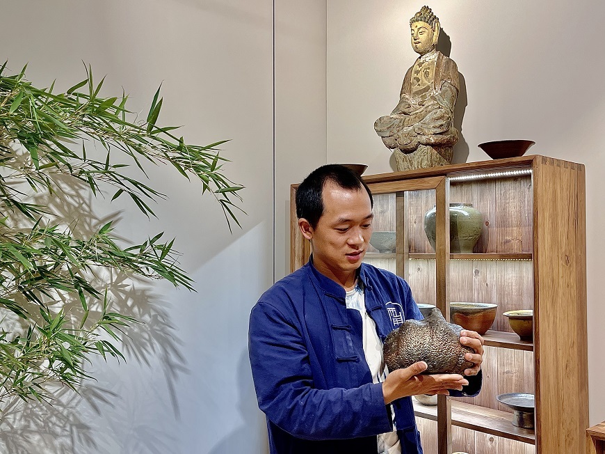 Guan Yongshuang introduces his pottery works in his studio.