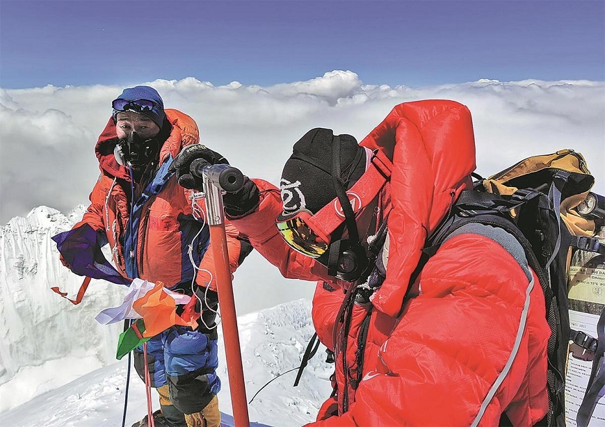 Members of the Chinese scientific expedition team reach the summit of Qomolangma on Wednesday, setting up a weather station on the world's highest mountain. SONAM DORJE/XINHUA