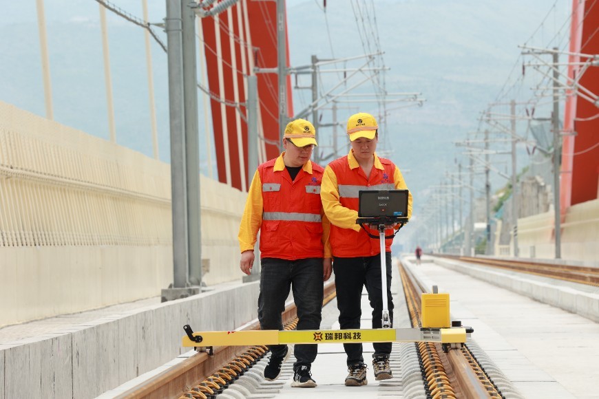 Hu Zehao and his colleague are using a track detector to check the track fine adjustment quality of the Chongqing section of the Zhengzhou-Wanzhou high-speed railway.