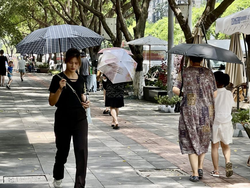 Chongqing citizens hold umbrellas under the scorching sun
