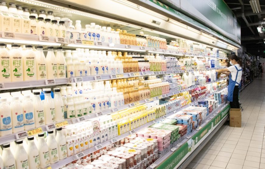A staff is replenishing milk at Longzhou store of New Century Department Store