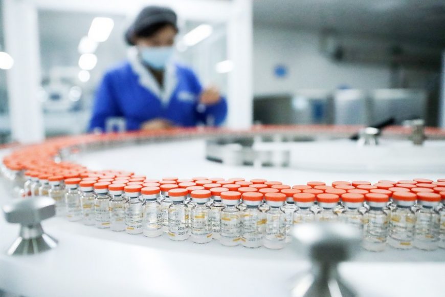 A staff member checks vials of inactivated COVID-19 vaccine on an automated packaging line of Sinovac Life Sciences Co., Ltd. in Beijing, capital of China, Dec. 23, 2020.