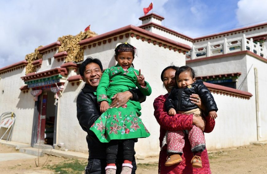 Local residents pose for a photo in front of their new house in Gurum Township of Lhasa, southwest China's Tibet Autonomous Region, April 2, 2020.