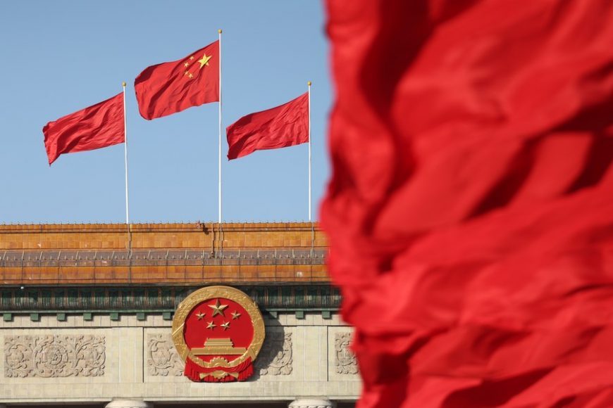 This photo taken on Oct. 16, 2022 shows flags on the Tian'anmen Square and atop the Great Hall of the People in Beijing, capital of China.