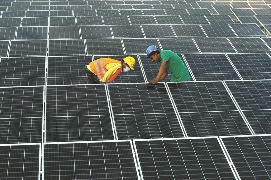 Workers assemble photovoltaic modules on the roof of a Chinese factory in Dhaka, Bangladesh, in January last year.